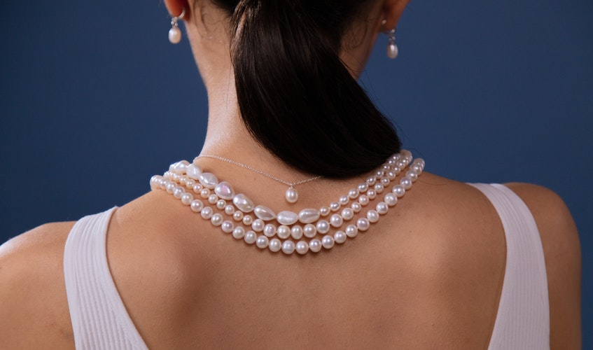 mujer luciendo collar tras limpiar perlas naturales